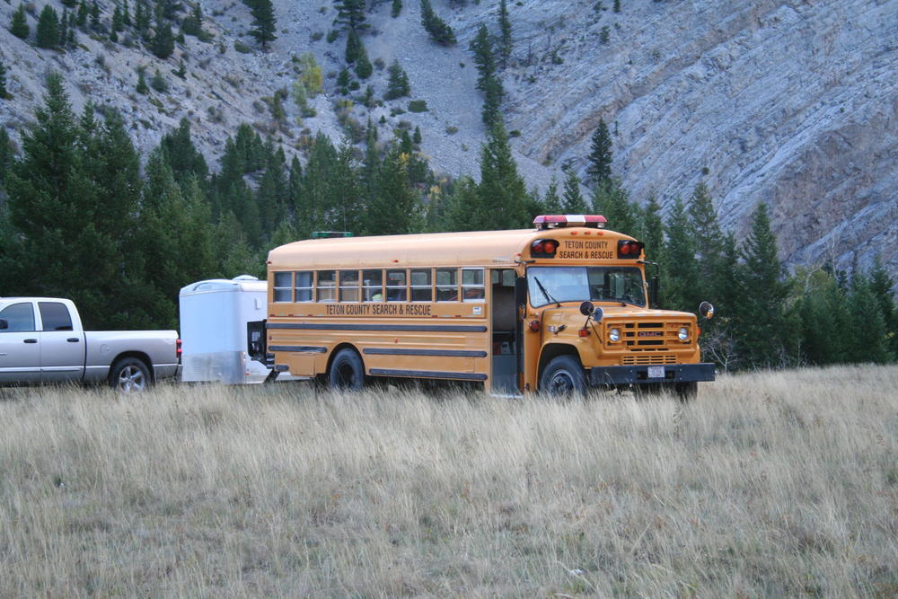 Teton County Search & Rescue bus parked in a field with mountains in the background